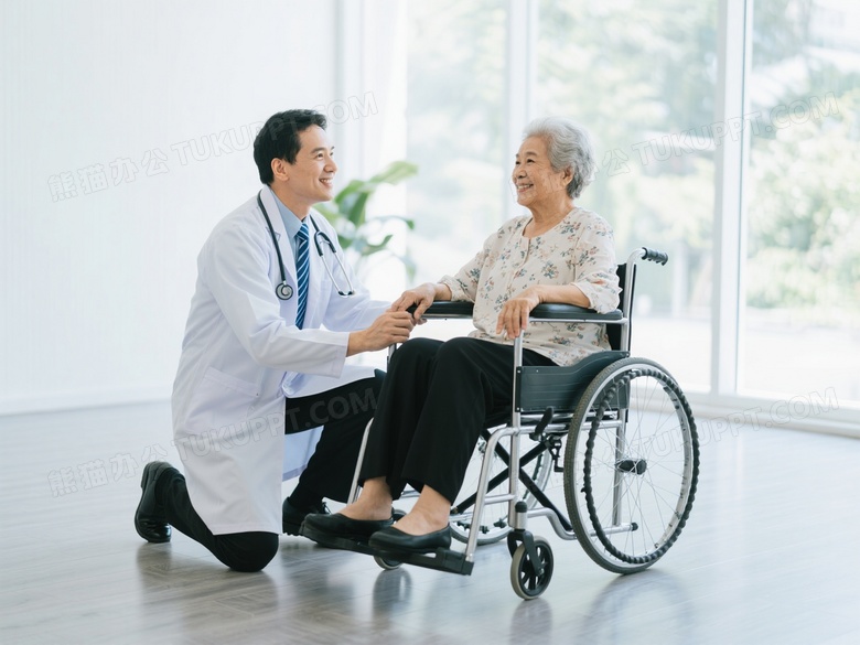 男医生跪扶轮椅与老人对视微笑图片